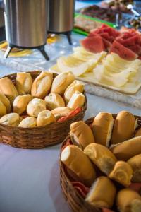 dos cestas llenas de sándwiches y fruta en una mesa en Vale Verde Coroa Vermelha, en Santa Cruz Cabrália