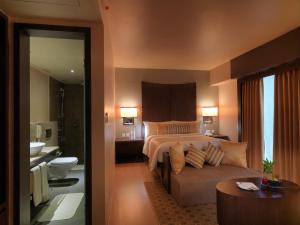pokój hotelowy z łóżkiem i kanapą w obiekcie The Quorum w mieście Mysuru