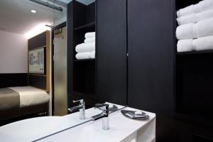 Un baño con lavabo, espejo y toallas. en The Z Hotel Covent Garden, en Londres