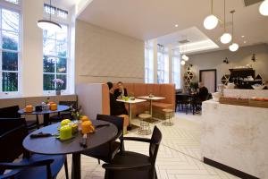Un restaurante con mesas y sillas y gente sentada en las mesas. en The Z Hotel Covent Garden, en Londres