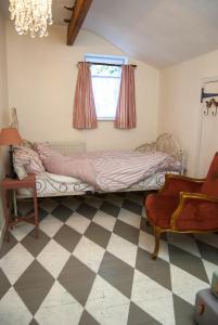 a bedroom with a bed and a window and a chair at The Broken Dish - Full Cottage Apartment in Mendham