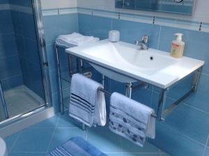 La salle de bains est pourvue d'un lavabo, d'une douche et de serviettes. dans l'établissement Appartamenti la Castagna, à Abbadia San Salvatore