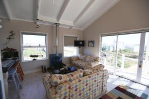 ein Wohnzimmer mit 2 Sofas und 2 Fenstern in der Unterkunft Reddoor Studio in Pringle Bay