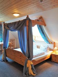 a bedroom with a wooden bed with a canopy at Landgasthof Zum Schwarzen Grat in Isny im Allgäu