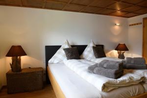 a bedroom with a large white bed with two lamps at Chalet "Altes Schulhaus" in Schruns