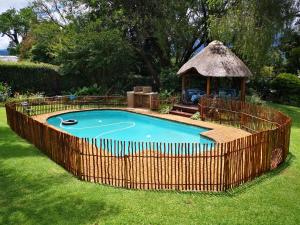 a swimming pool with a gazebo in a yard at Dublin Guest House in Sabie