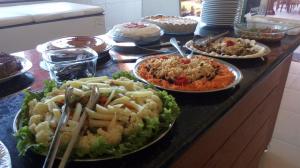a buffet with many plates of food on a counter at Rancho das Montanhas in Muniz Freire