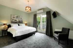 a bedroom with a bed and a chair and a window at Slaap bij TRIX in Arnhem +9 photos