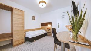 a room with a bed and a table with a dining room at Boutique-Hotel Kronenstuben - unschlagbare Zentrumsnähe direkt am Marstall & Marktplatz - Schloss in 3 Min - Frühstück - Langzeitmiete in Ludwigsburg