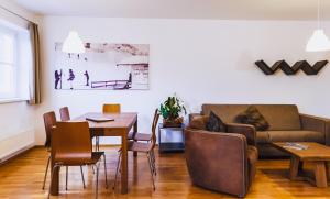 salon ze stołem i kanapą w obiekcie Alpine Resort by Alpin Rentals w Kaprunie
