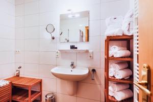 une salle de bain avec un lavabo, un miroir et des serviettes dans l'établissement Alpine Resort by Alpin Rentals - incl Summercard, à Kaprun 27 autres photos