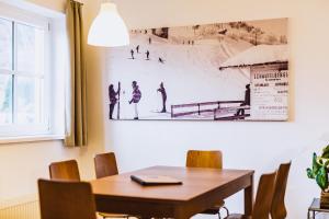 منتجع ألبين باي ألبين رينتالز في كابرون: غرفة طعام مع طاولة وصورة على الحائط