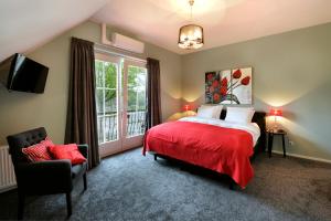 a bedroom with a red bed and a window at Slaap bij TRIX in Arnhem