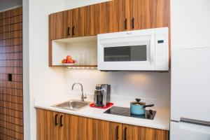 uma cozinha com um lavatório e um micro-ondas em Uptown Suites Extended Stay Denver CO -Westminster em Westminster