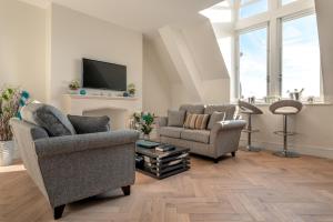 a living room with two chairs and a fireplace at Cathedral View - An Exclusive Private Apartment on Cathedral Green, Exeter in Exeter