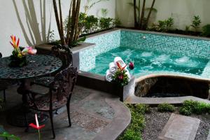 uma pequena piscina com mesa, mesa e cadeiras em Rincon del Valle Hotel & Suites em San José