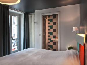 a bedroom with a large bed and a window at Hôtel des Métallos in Paris