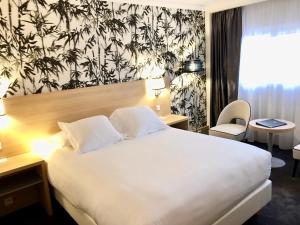 a hotel room with a large white bed and a window at Hotel Inn Paris CDG Airport - ex Best Western in Roissy-en-France
