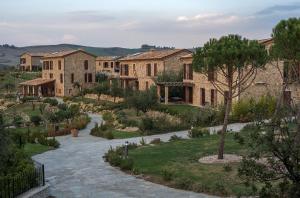 una gran casa de piedra con un árbol en el patio en Tuscany Forever Sunset Apartments, en Volterra