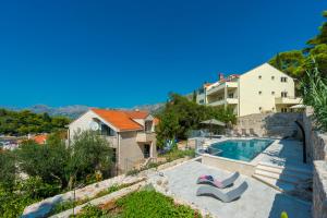 a villa with a swimming pool and a house at Apartment Obradovic in Cavtat