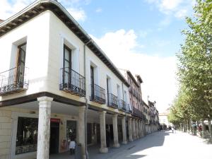 un edificio con columnas y balcones en una calle en La Casa Tahona Plaza de Cervantes, en Alcalá de Henares