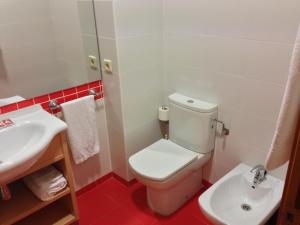 La salle de bains est pourvue de toilettes blanches et d'un lavabo. dans l'établissement Hotel Viñas 17, à Teruel