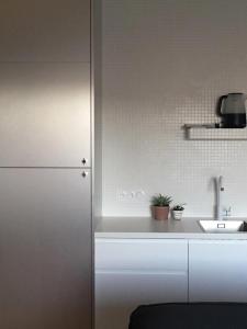 a kitchen with a white refrigerator and a sink at Joie Paris Porte Maillot - Palais Des Congrès in Neuilly-sur-Seine
