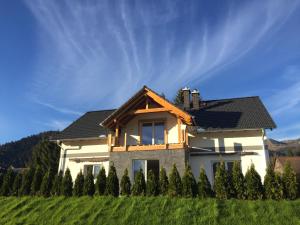 a house in a field with a row of trees at Alpenapartments Steiermark in Bad Mitterndorf