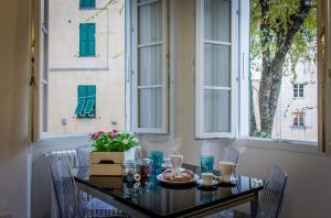 un tavolo con un piatto di cibo sopra davanti a una finestra di Casa della Boga a Finale Ligure