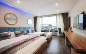 a hotel room with two beds and a mirror at Oriana Hotel in Hanoi +24 photos