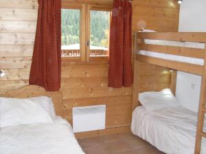 a bedroom with two bunk beds and a window at Spacious Apartment 2 Minutes from Ski Lift, Equipped for Babies in Les Houches
