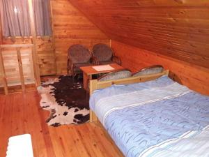 a bedroom with a bed and two chairs and a table at Apartmani Etno in Jahorina