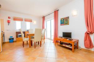 a living room with a dining room table and a television at Quinta Velha By Algartur in Cabanas de Tavira