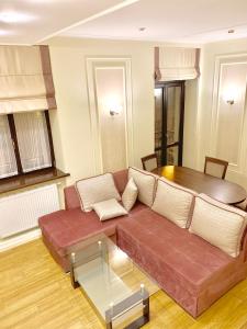 een woonkamer met een bruine bank en een tafel bij Two-bedroom on Lesi Ukrainky in Lviv