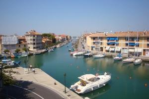 un barco está atracado en un río junto a los edificios en Riviera Appartament, en Grado
