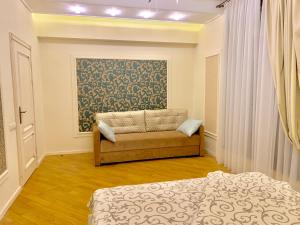 een slaapkamer met een bank en een schilderij aan de muur bij Two-bedroom on Lesi Ukrainky in Lviv
