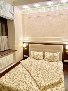 een slaapkamer met een groot bed met een hoofdeinde bij Two-bedroom on Lesi Ukrainky in Lviv