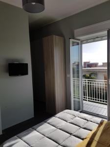 トッレ・デル・グレーコにあるB&B Vincenzoのベッドルーム1室(ベッド1台付)、窓、バルコニーが備わります。