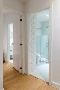 a white room with a door and a bathroom at Apartamento minimalista en el corazón de Bilbao in Bilbao +23 photos