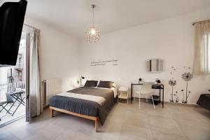 a bedroom with a bed and a table with chairs at Piazza Salvatore 7, gocce di sicilia in Ragusa