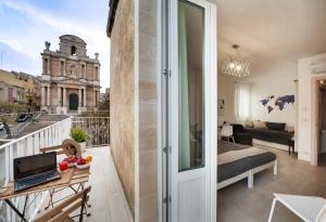 a apartment with a balcony with a view of a building at Piazza Salvatore 7, gocce di sicilia in Ragusa