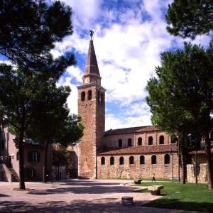 a large brick building with a tower with a clock at Villa Gradenigo in Grado