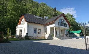 a white house with a black roof on a driveway at Villa Julia in Krakow +17 photos