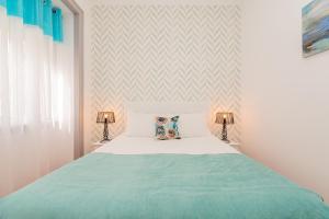een slaapkamer met een bed met een groene deken en 2 lampen bij Lisbon Times Apartments in Lissabon