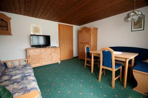 a room with a table and chairs and a tv at Pension Arnspitze in Scharnitz