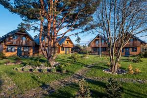 a log home with trees in the yard at Domki Jasna Polana in Jastrzębia Góra