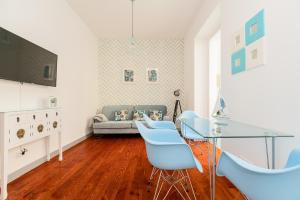 een woonkamer met een glazen tafel en blauwe stoelen bij Lisbon Times Apartments in Lissabon