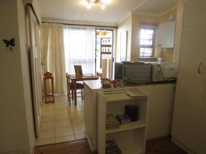 a kitchen with a counter and a table in a room at Dempsey's Self-Catering Guest House in Port Elizabeth