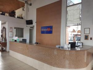 a lobby with a large counter with a sign on the wall at State Inn in Chihuahua