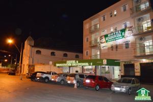 un grupo de coches estacionados frente a un edificio en Hotel e Restaurante Residencial, en Montes Claros